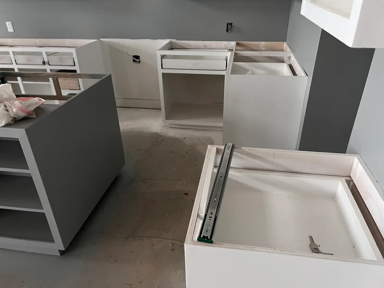 White and grey kitchen cabinet bases without countertops during installation