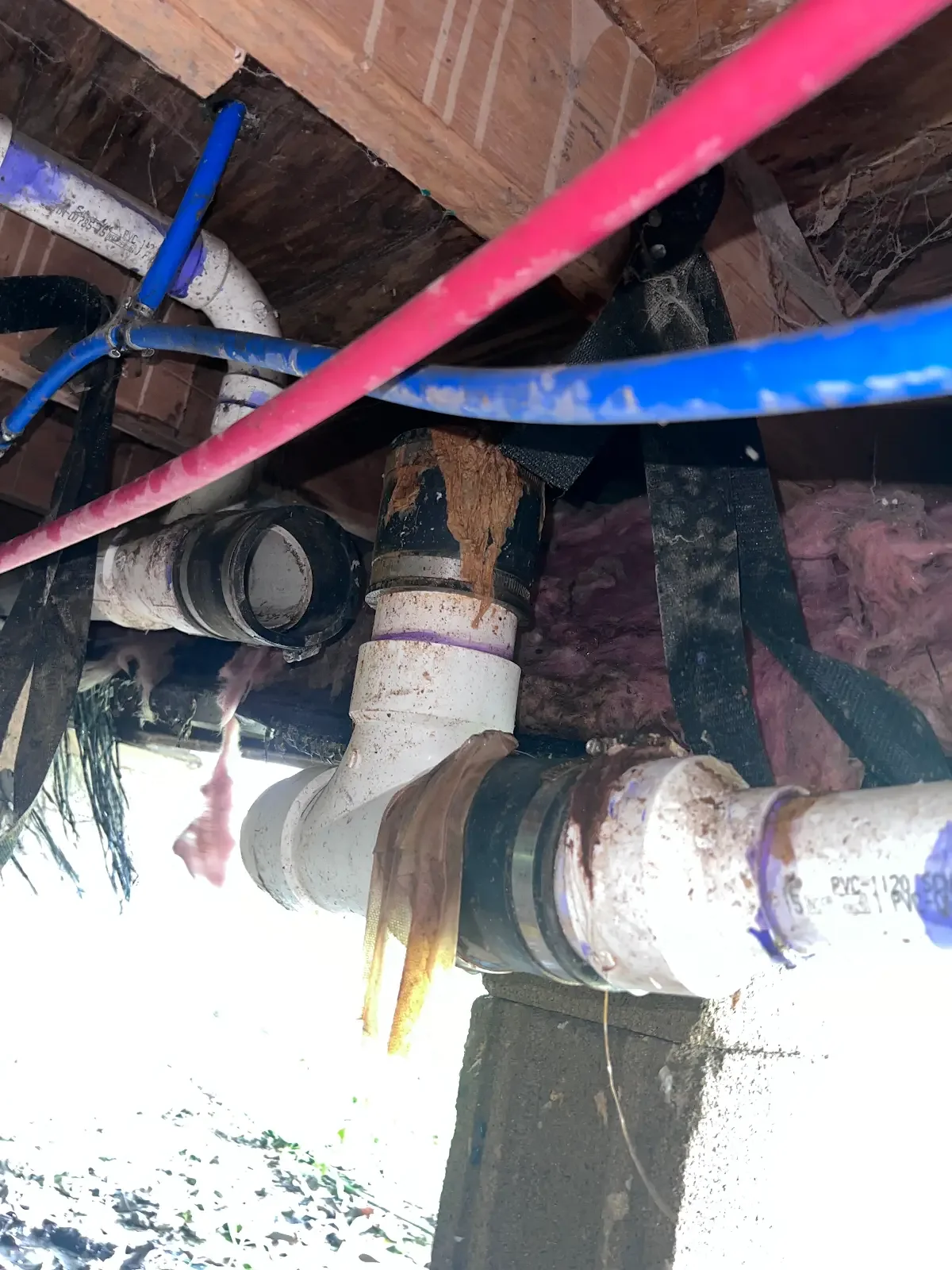 Underfloor pipework with red and blue lines and existing metal fittings